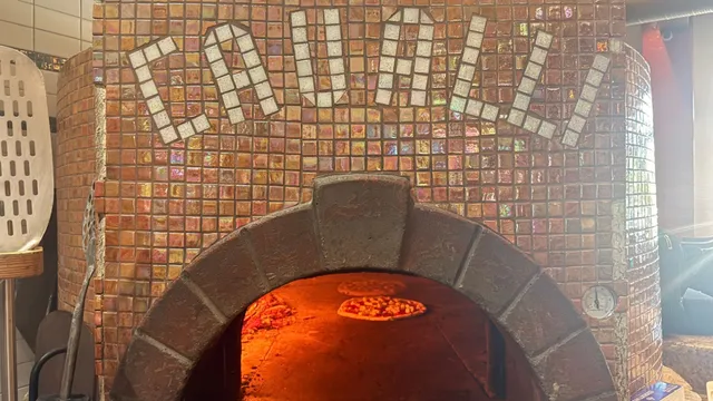 Cavalli's wood-fired brick oven, with the restaurant's name in tile mosaic above the arch