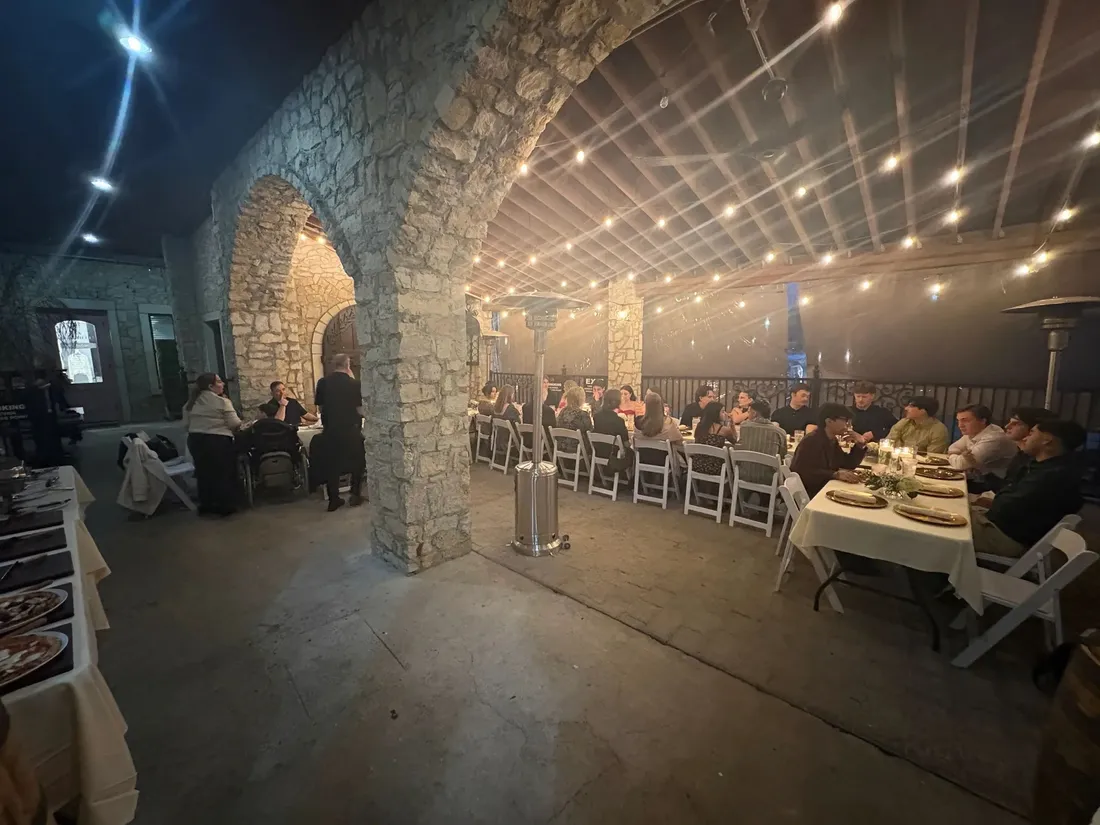 Guests seated at a private event on Cavalli's Back Patio, string lights overhead
